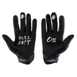 Pair of black USWE NO BS Off-Road Gloves displayed palm-up showing bold white graphic print reading "BULL S**T" and "0%" with hashtag symbols on fingers, highlighting the superlight construction and textured grip palm for enduro and motocross riding.