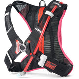 USWE lightweight race hydration pack with black mesh harness, pink accents, and No Dancing Monkey 4-point harness system for mountain biking and gravel racing.