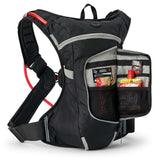 USWE motorcycle hydration pack in black with red hydration tube, wide elastic waist strap, and front pocket open showing organized storage compartments with emergency supplies and energy gels.
